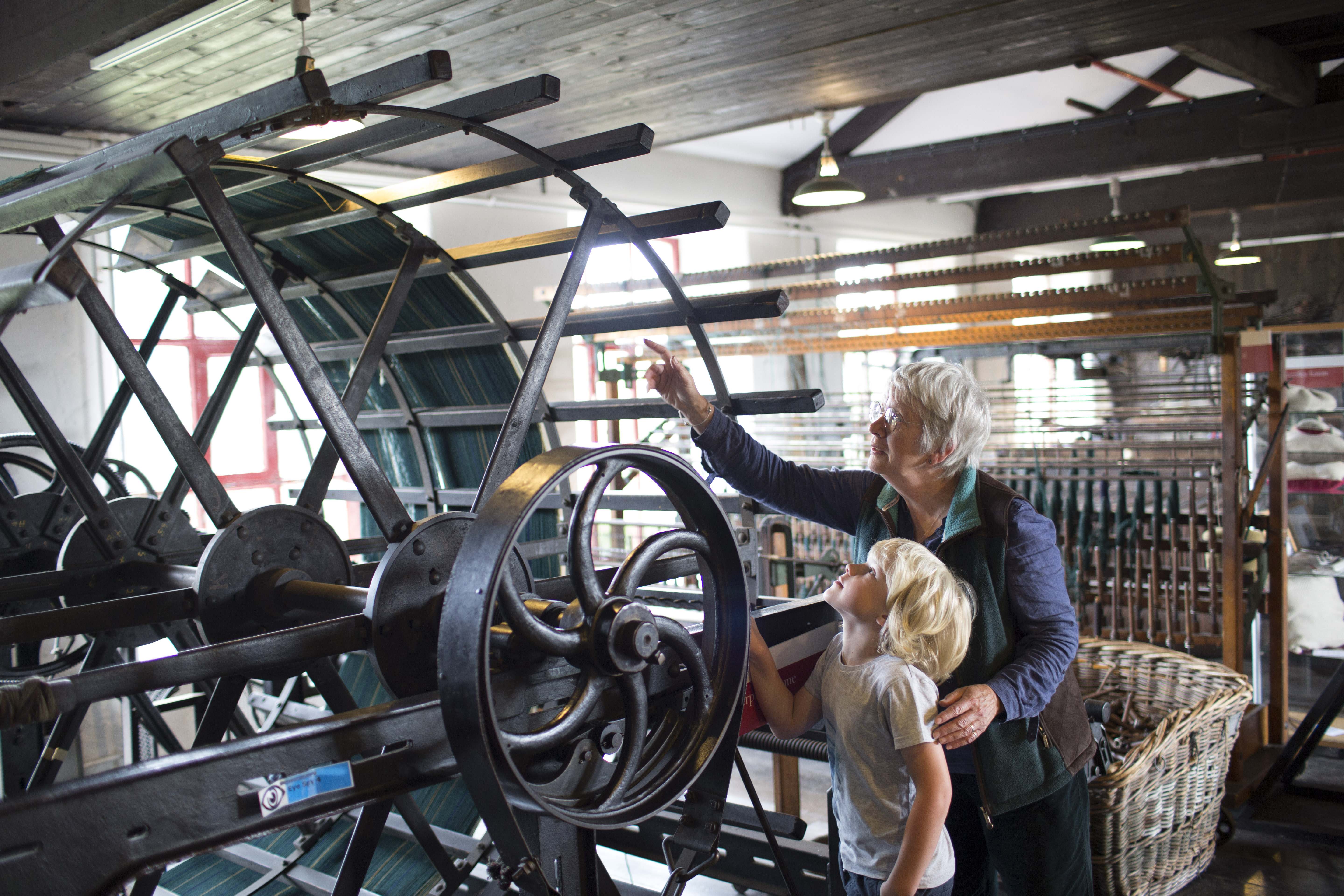 A grandparent and child looking at an industrial exhibit in Leeds Industrial Museum