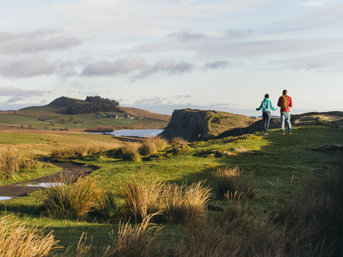 Dos jóvenes caminando por la campiña de Northumberland, Reino Unido.