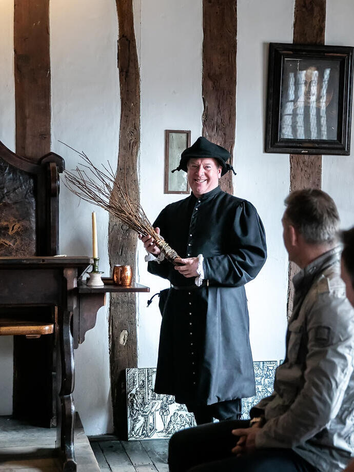 A tour guide showing exhibits at Shakespeare's Classroom in Stratford-upon-Avon
