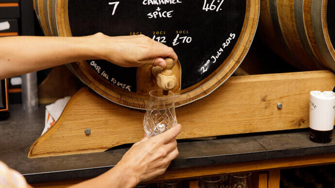 Whisky versato da una botte in un negozio