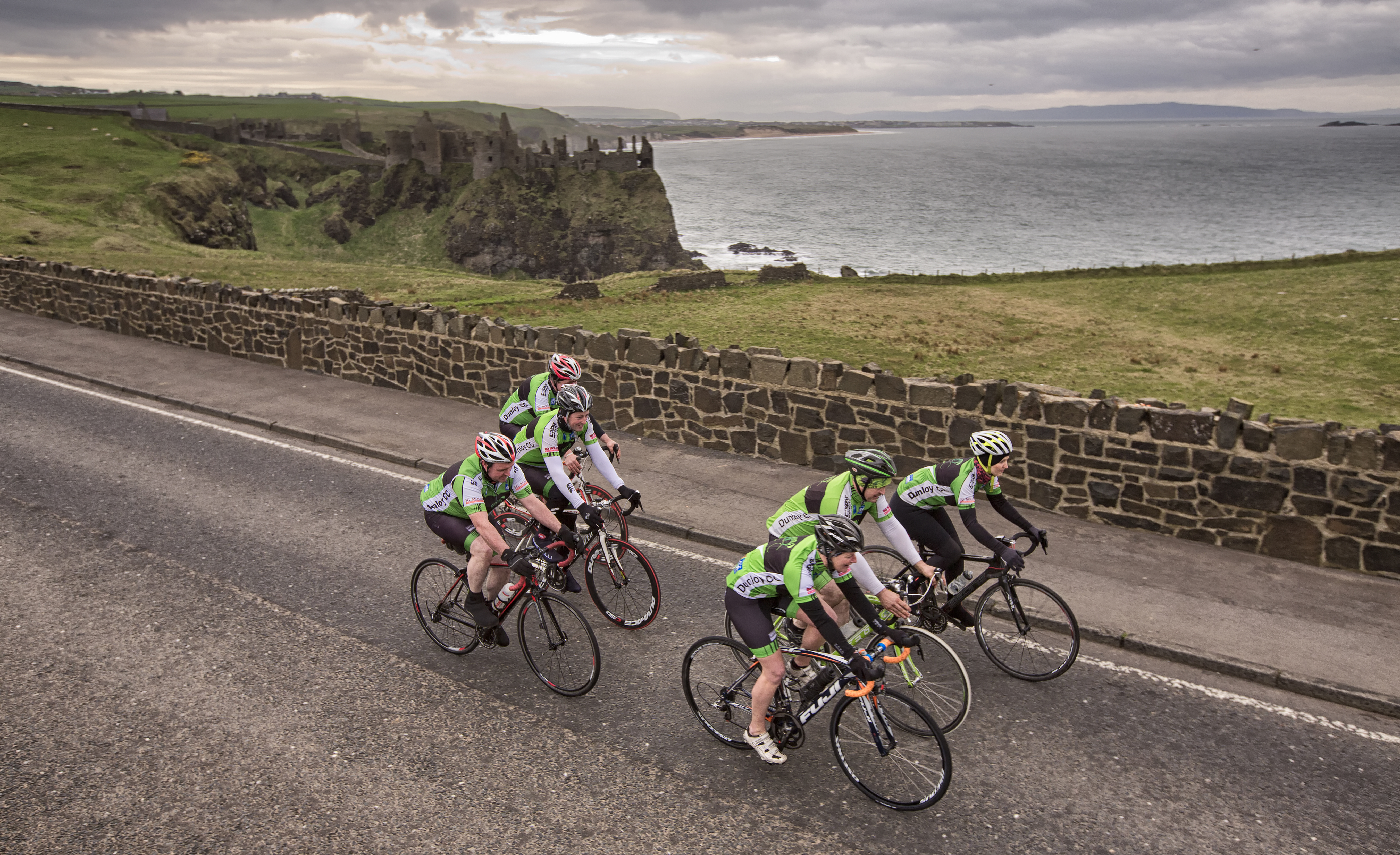 Group of people cycling on a seaside road