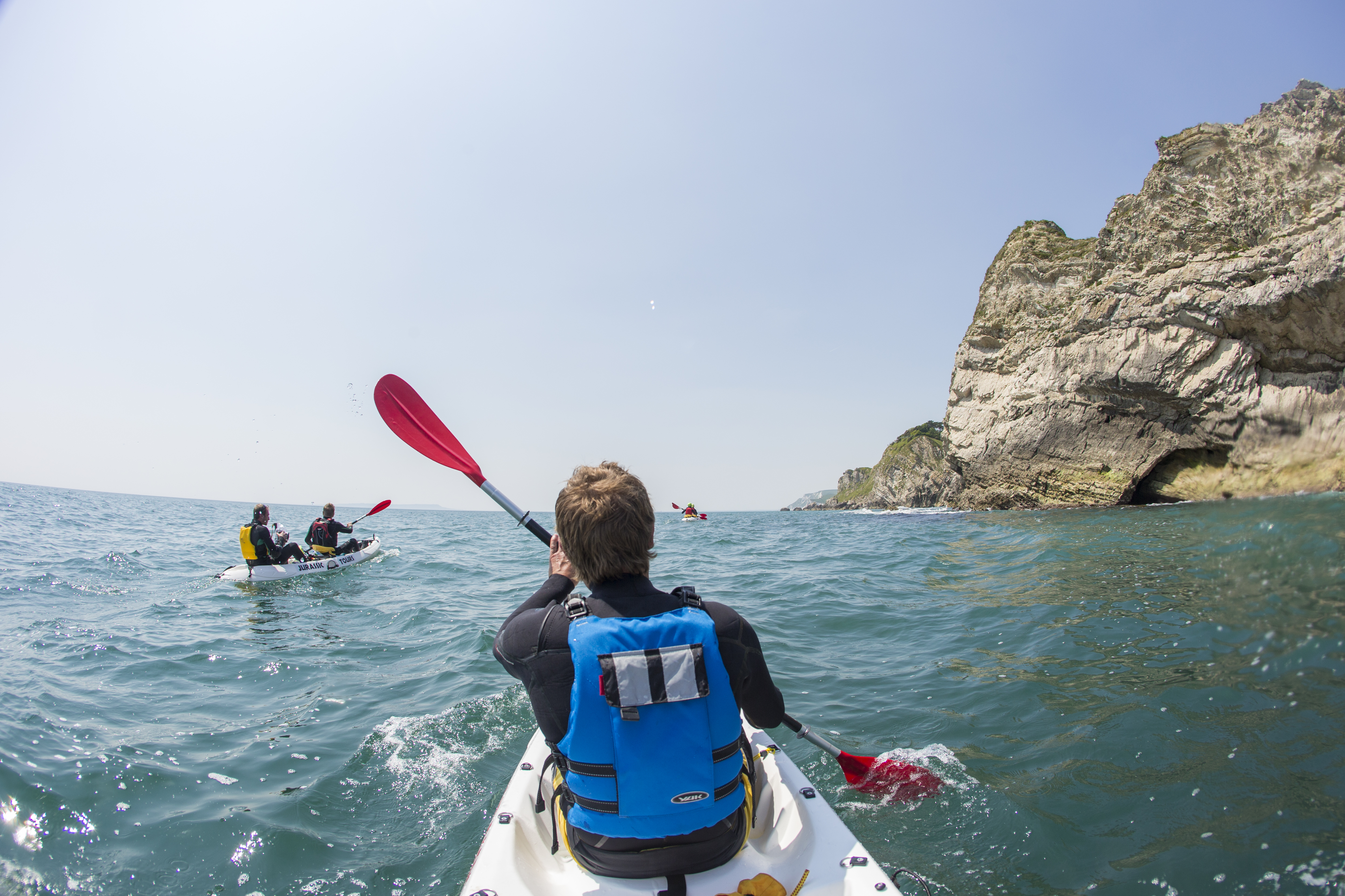 People kayaking along the shores of coastline