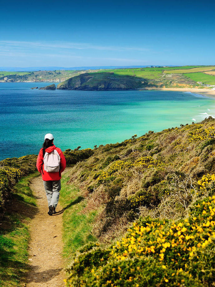 A person on a footpath on the coastal path near sea