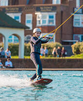 A woman water skiing and holding onto a line at Lagoon Watersports in Brighton