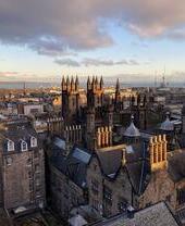 High view of rooftops of Edinburgh with sea beyond as seen from Camera Obscura World of Illusions attraction