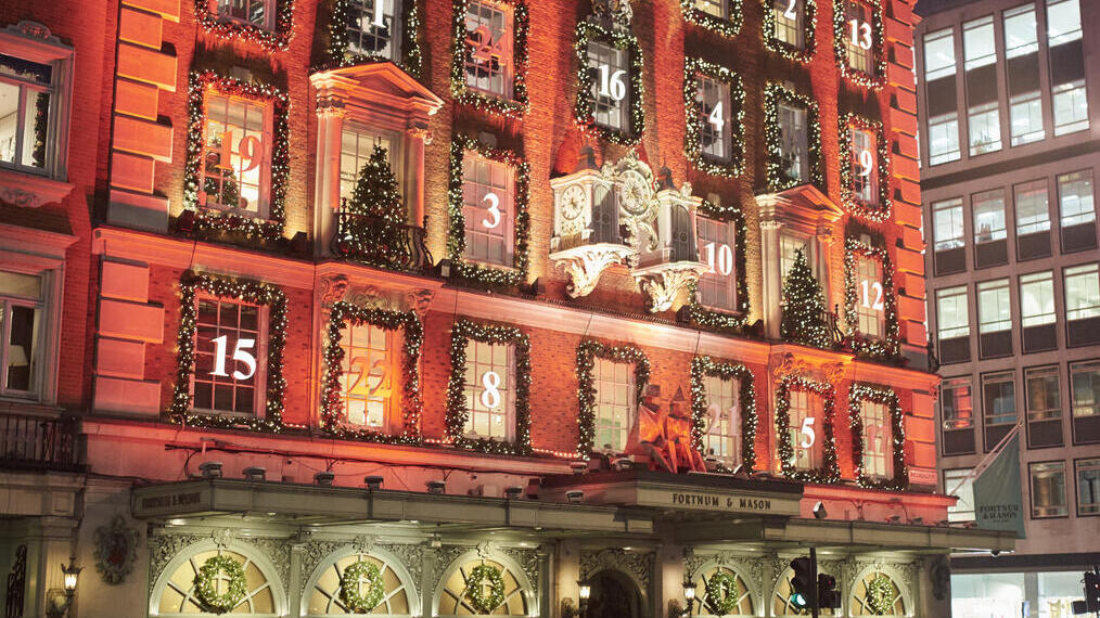 A crowd of people on the street outside a department store at night