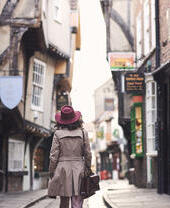 Woman walking through a narrow historic street in a city