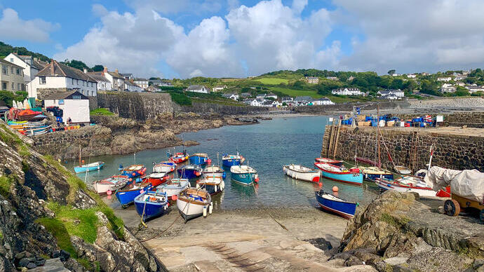 A quaint seaside village with moored boats and traditional housing.