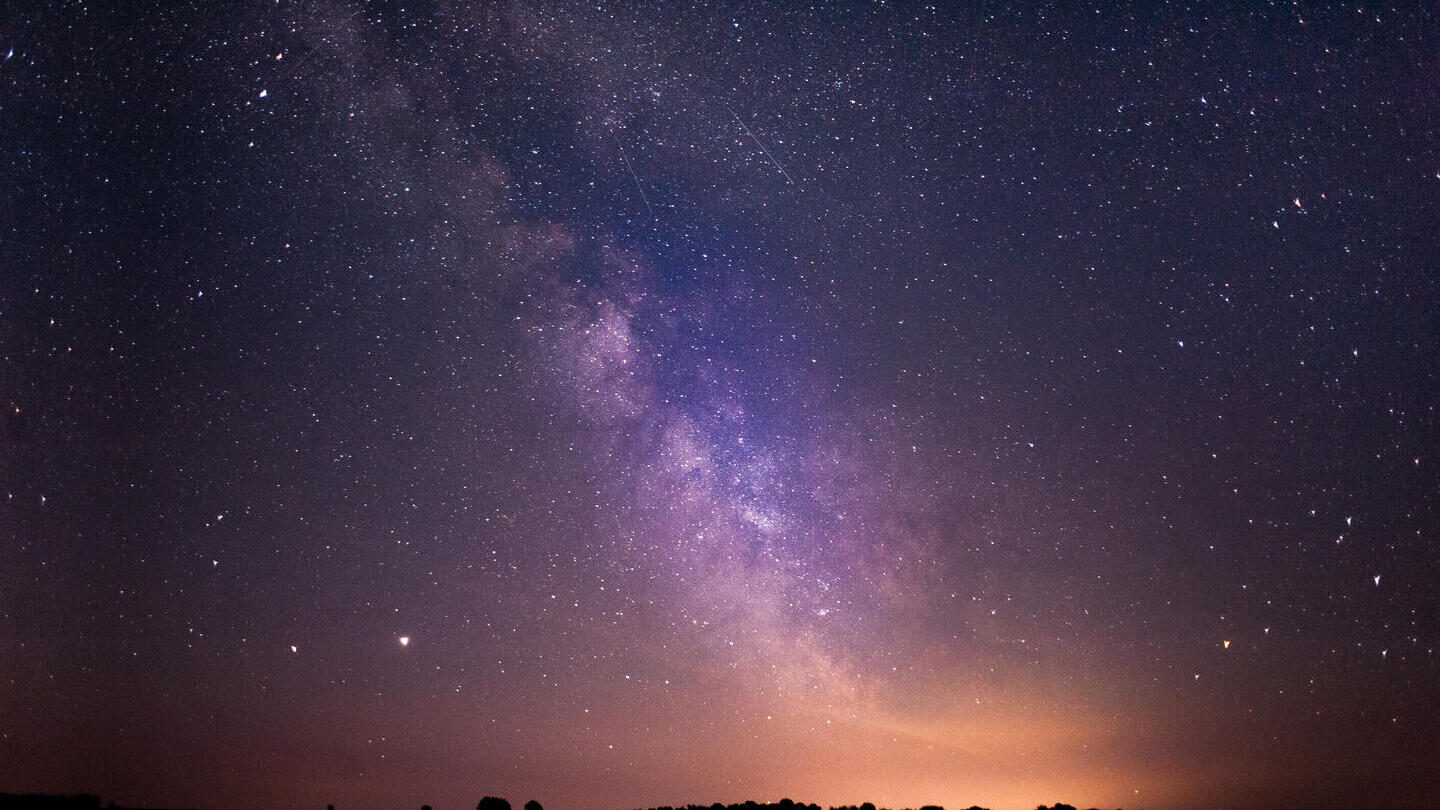 Les étoiles et la Voie lactée sont clairement visibles dans le ciel nocturne.