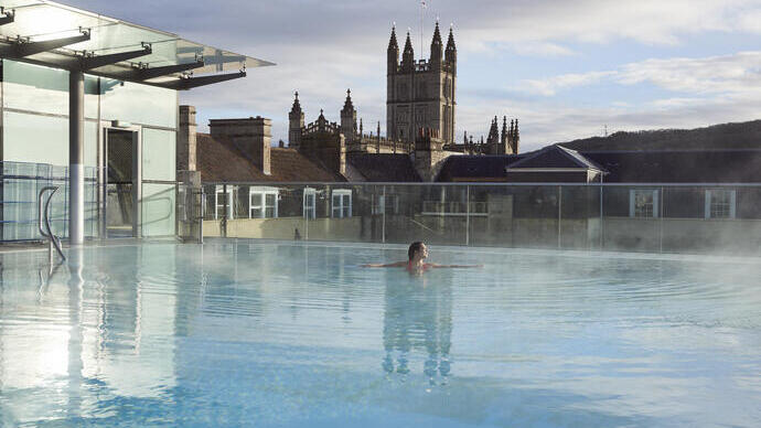 Woman in a roof top swimming pool at a spa