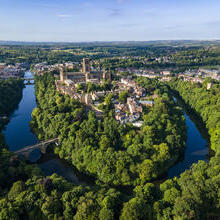 An elevated view of a Cathedral set amongst trees and a river