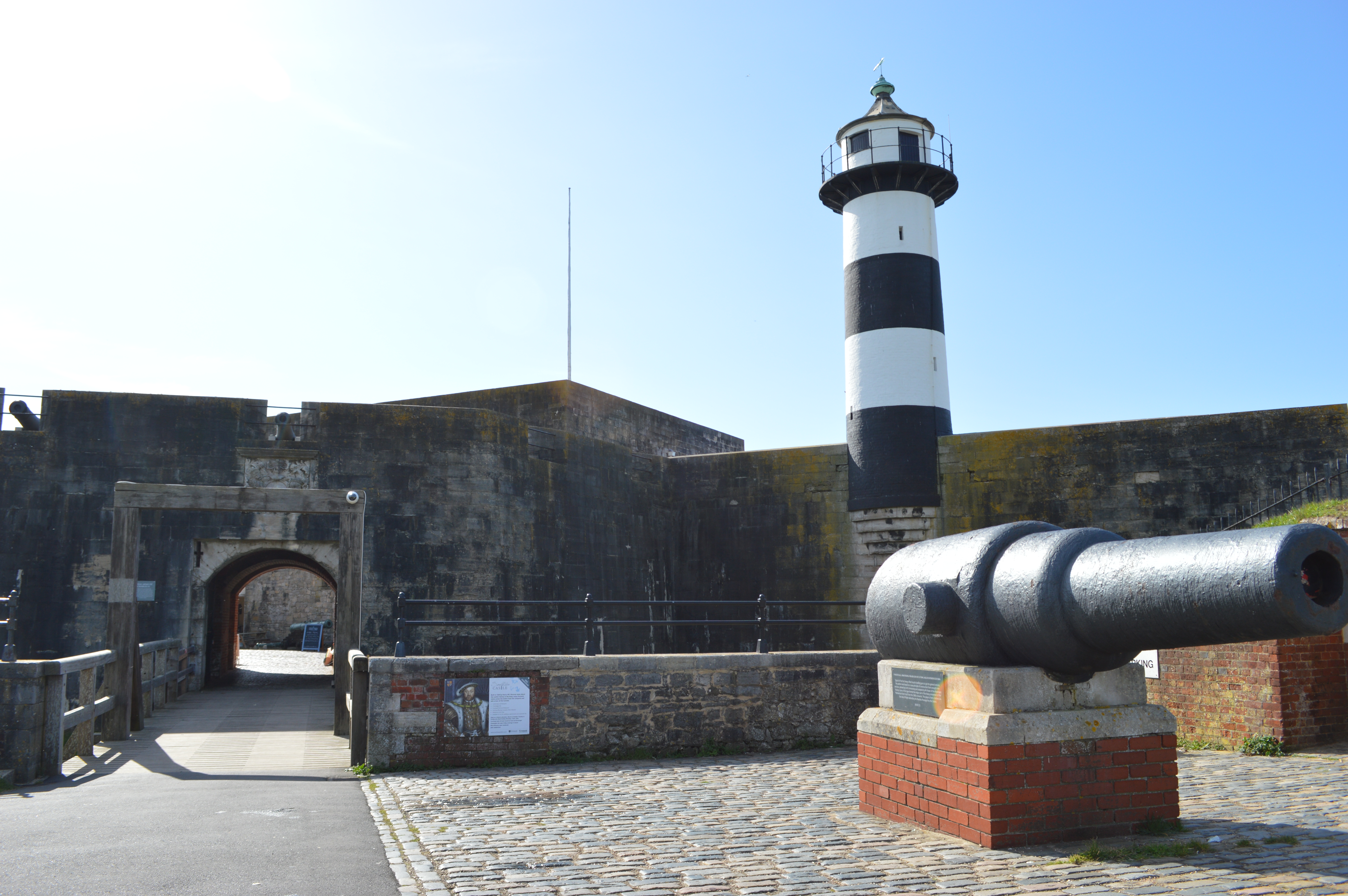 A lighthouse and cannon in the grounds of an old castle
