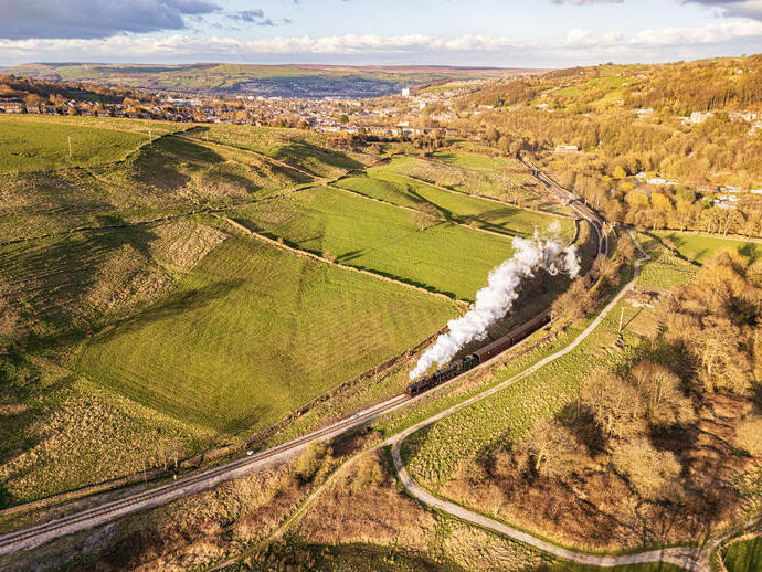 Steam train travelling along tracks in the countryside