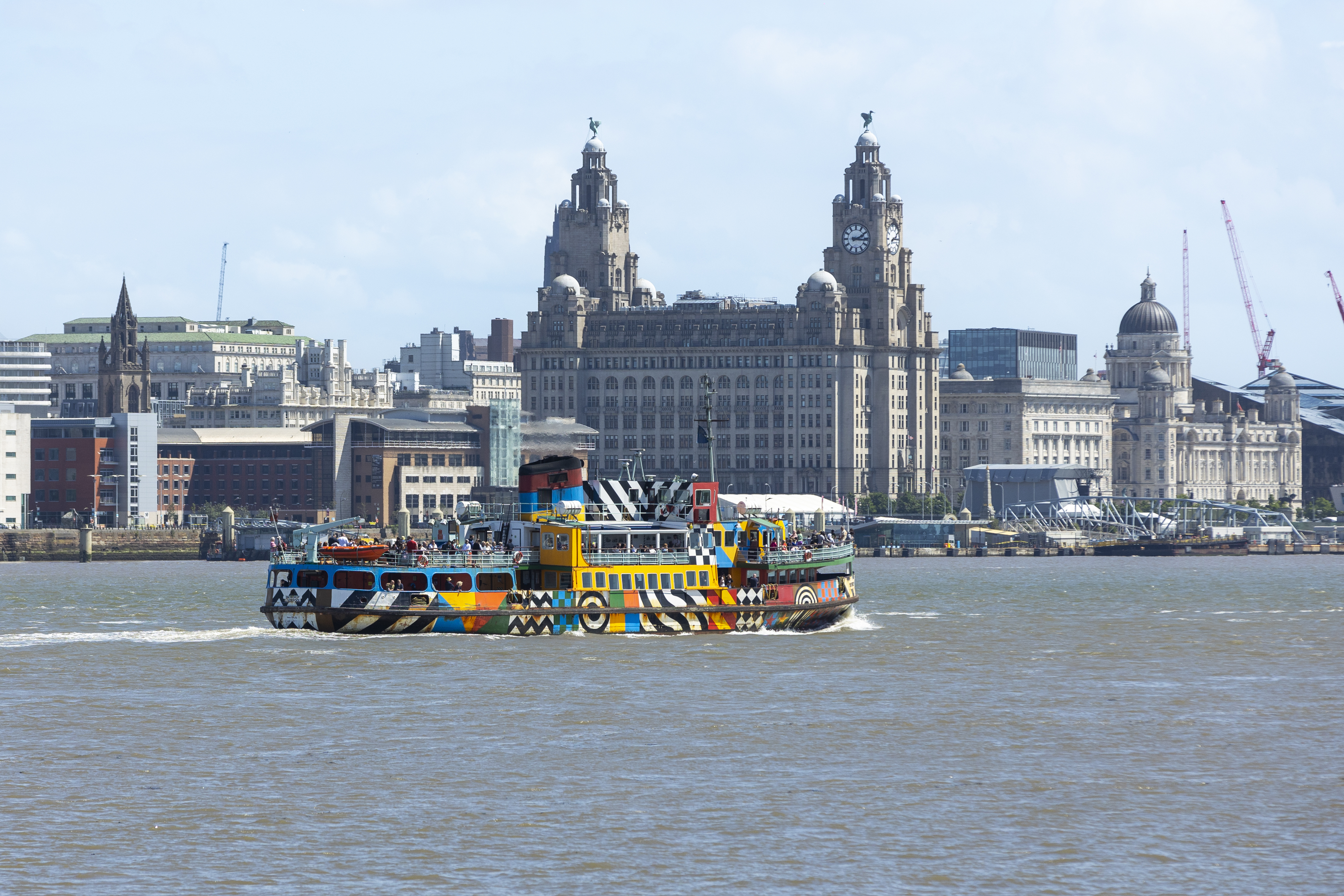 A view to a ferry on a river in front of an iconic building