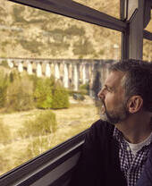 زوجان في القطار ينظران من النافذة إلى المناظر الطبيعية