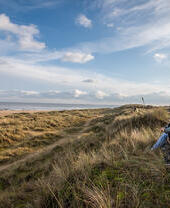 Un groupe de personnes admirant la mer depuis les dunes de Winterton