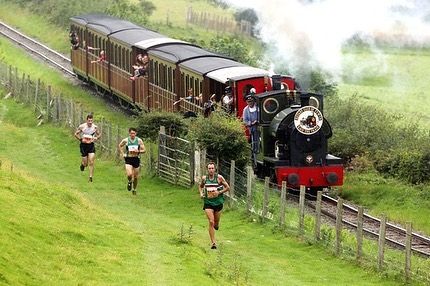 Épreuve Race The Train montrant les participants courant à côté d'un train à vapeur au Pays de Galles
