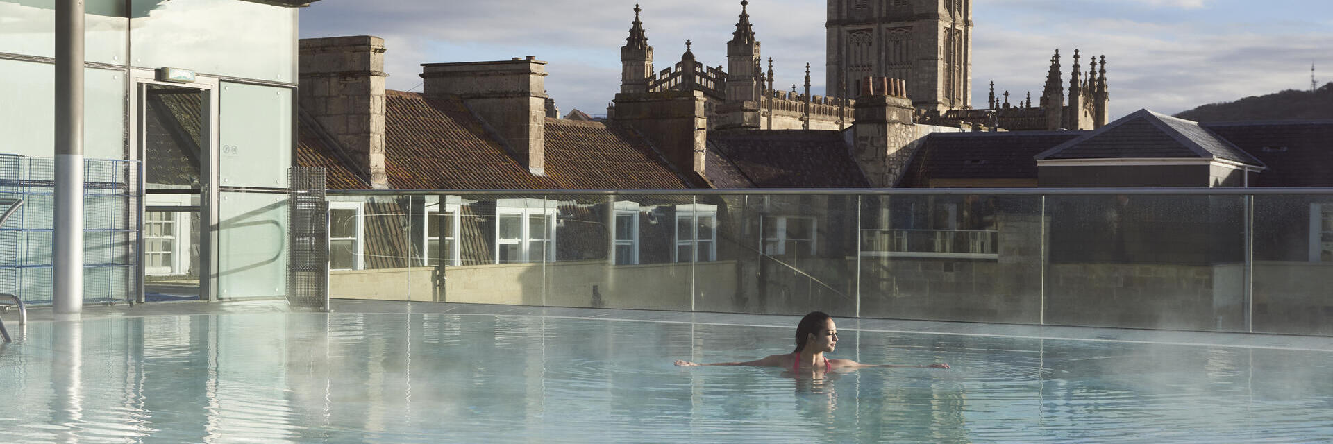 Woman in a roof top swimming pool at a spa