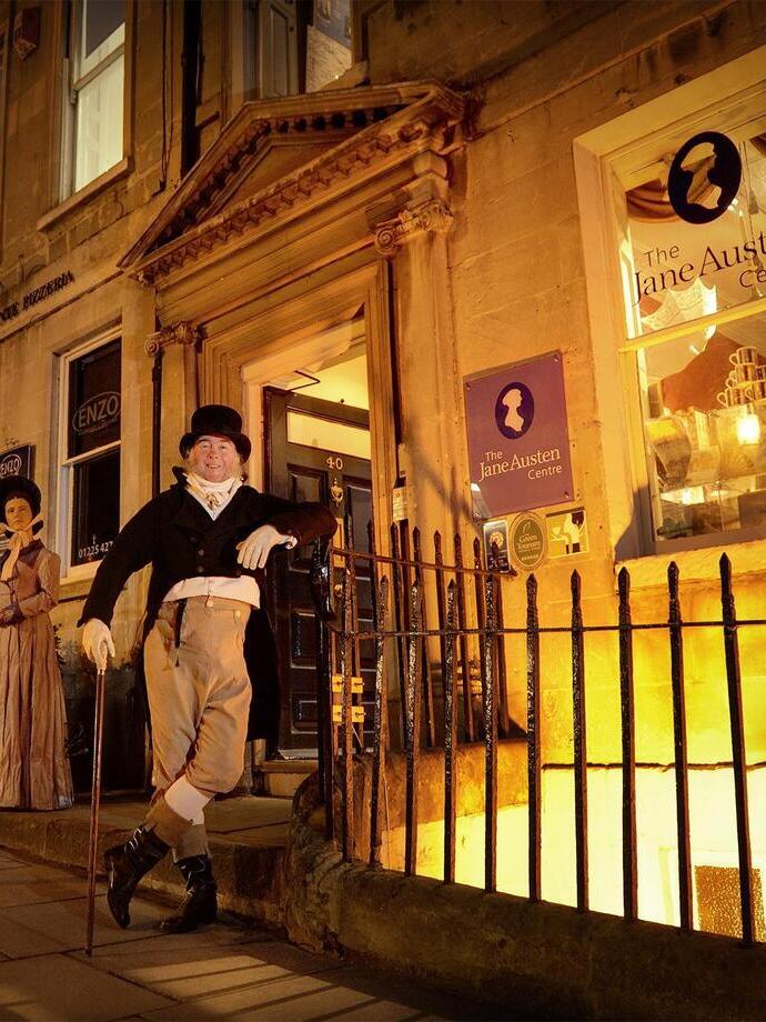 Zwei Personen in historischen Kostümen vor einem viktorianischen Museum.