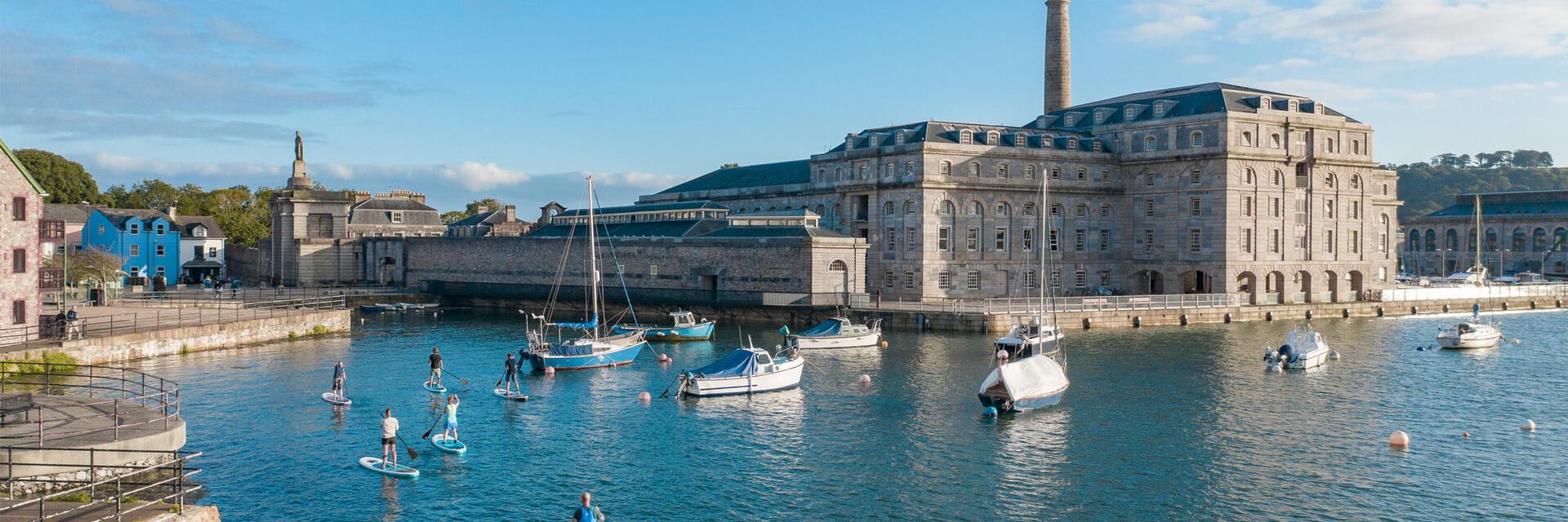 Des personnes faisant du paddleboard près d'un quai à Plymouth