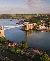 Landscape view of a suspension bridge over a river.