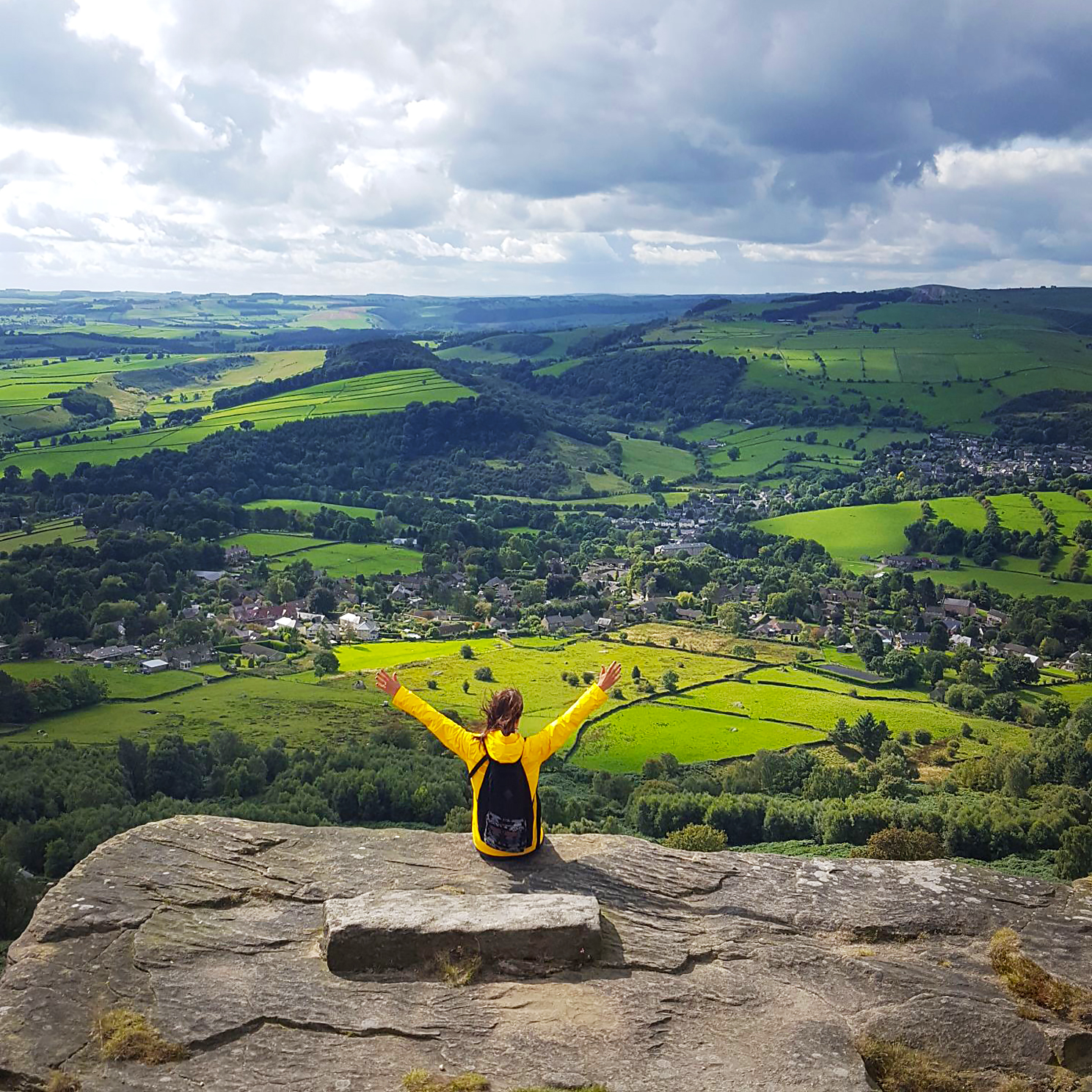 A woman with her arms raised enjoying the view from high