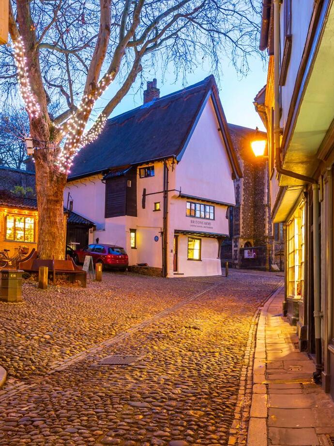A pretty village square with cobbled streets at dusk