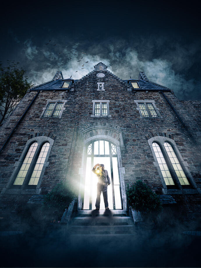 A warden with a lanturn stood in front of Bodmin Jail for a promotional shot