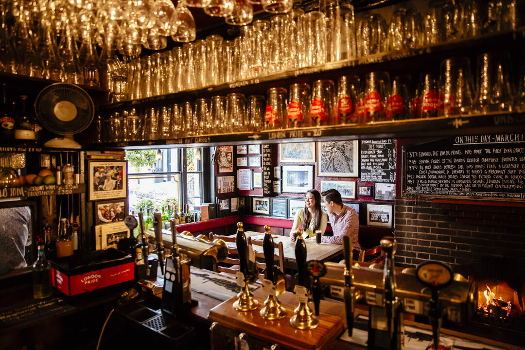 Couple sat at a table in a pub having a drink