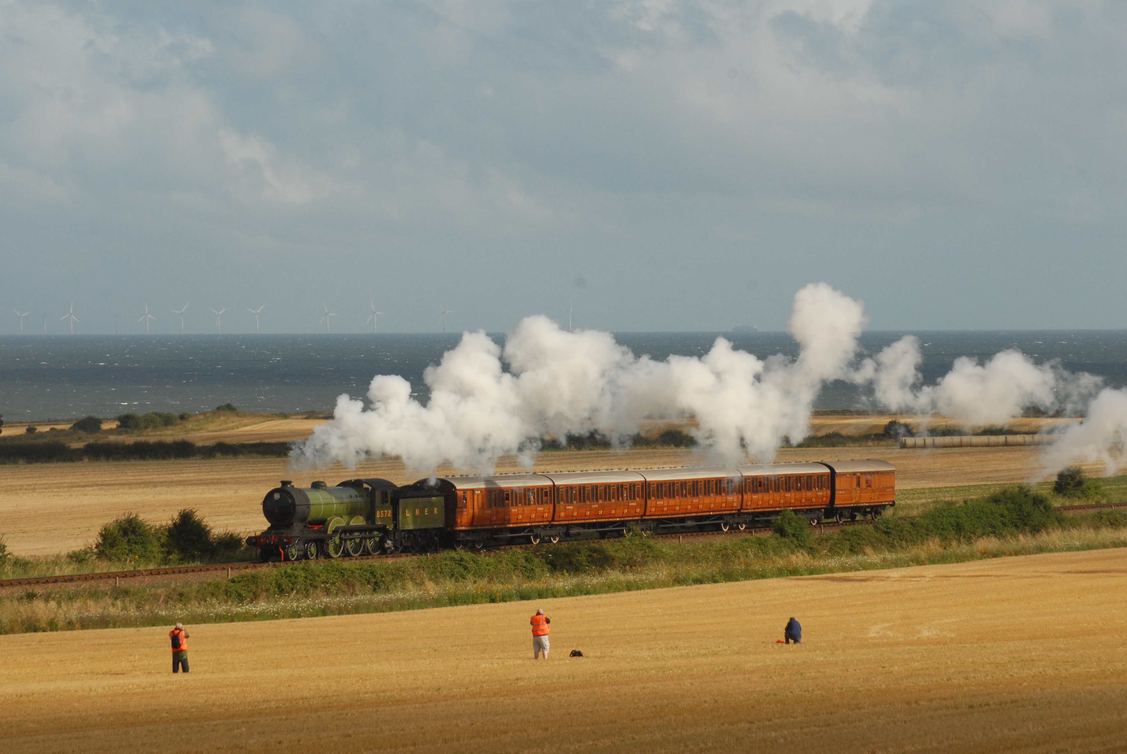 Un train à vapeur traversant les champs sur la côte