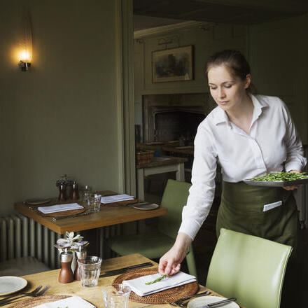 Woman setting a table in a restaurant