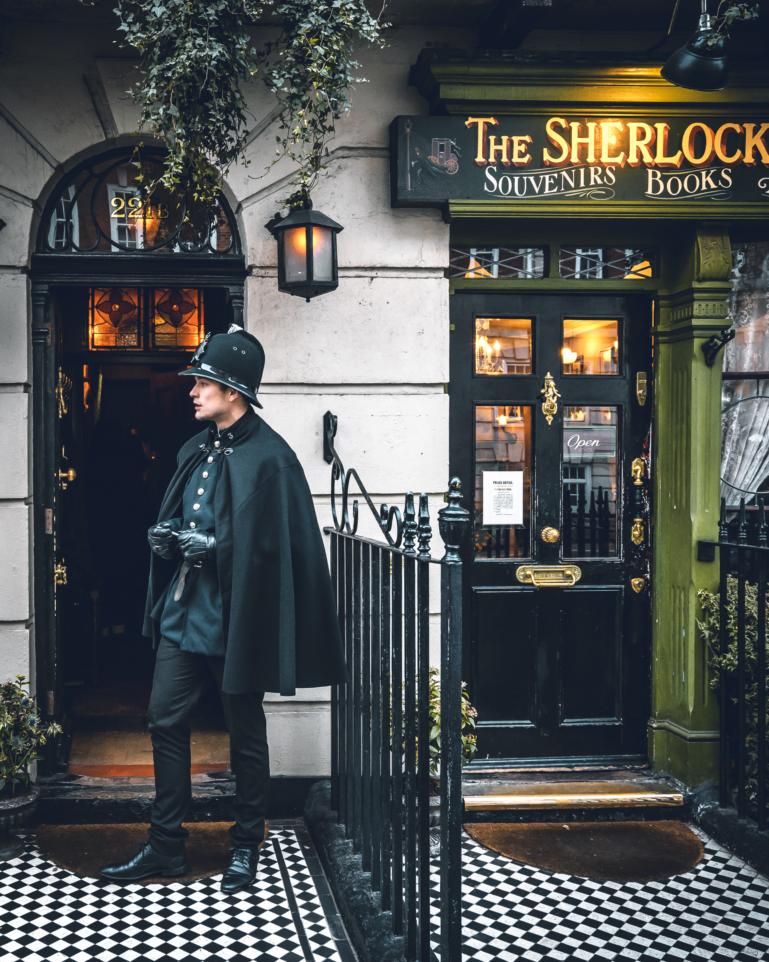 A man in an old style police uniform standing outside