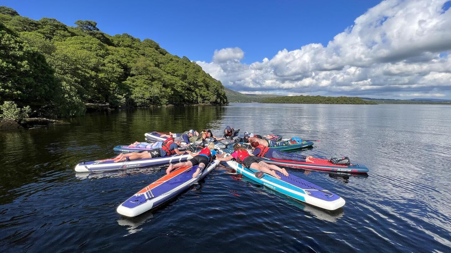 Paddleboarder sdraiati che formano una figura sul fiume Clyde a Glasgow