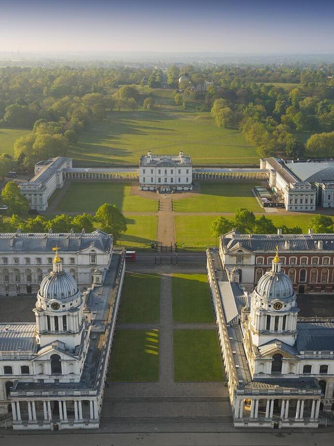 Aerial view of a massive mansion and manicured gardens.