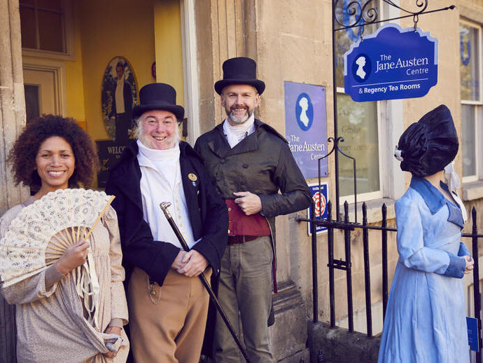 Besucher und Mitarbeiter in historischen Kostümen vor dem Jane Austen Centre in Bath, Somerset, England