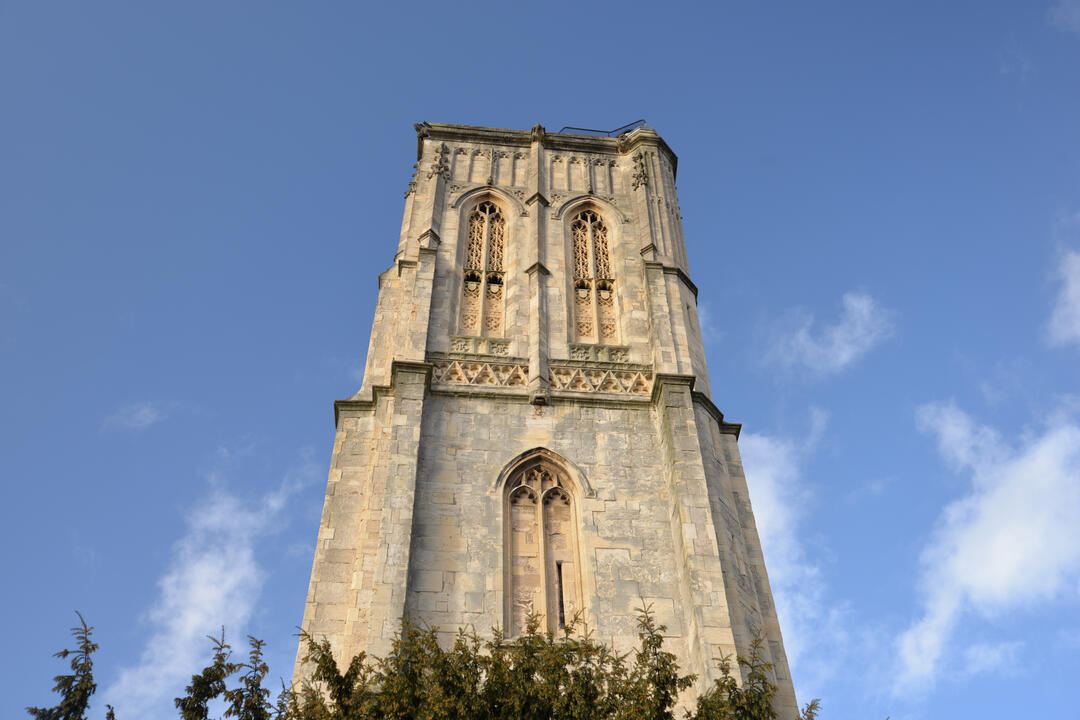Square church tower against blue sky