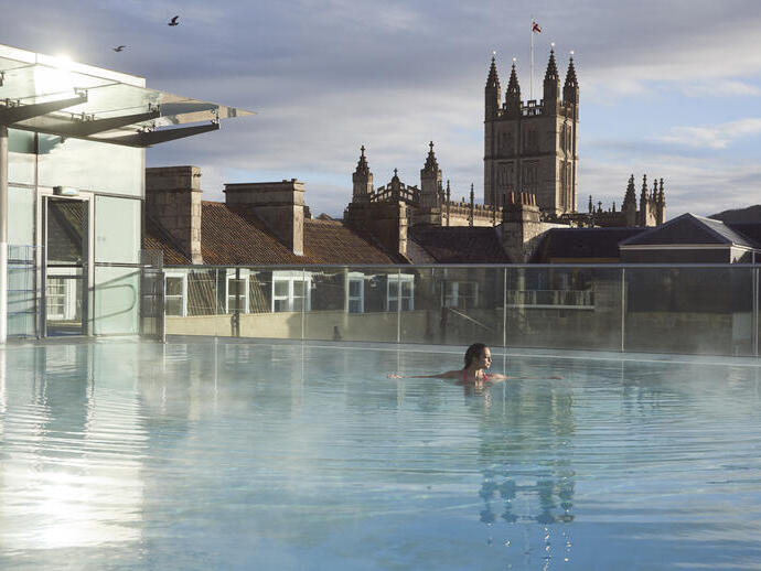Woman in a roof top swimming pool at a spa