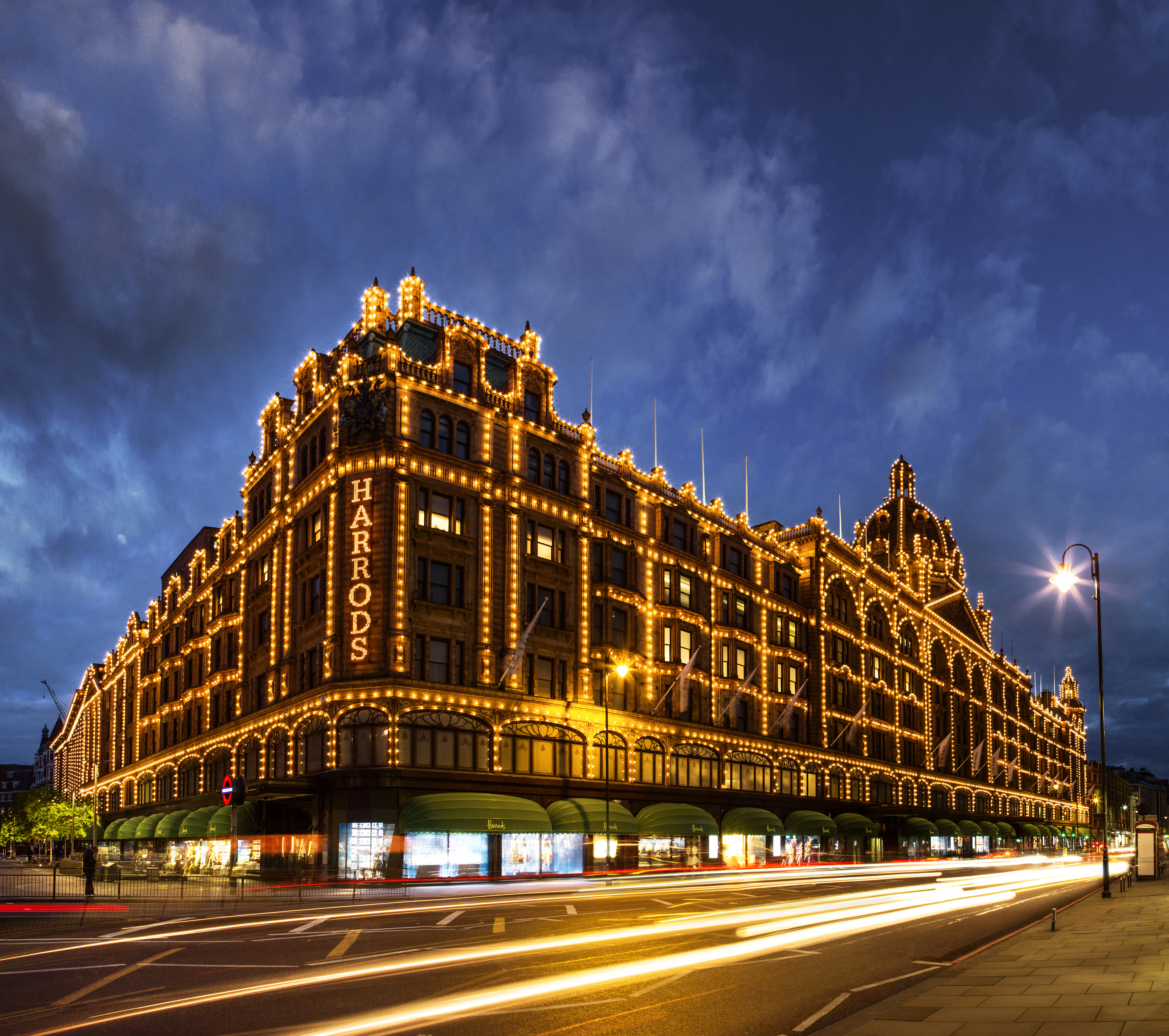 Harrods department store lit up at night. Dark skies
