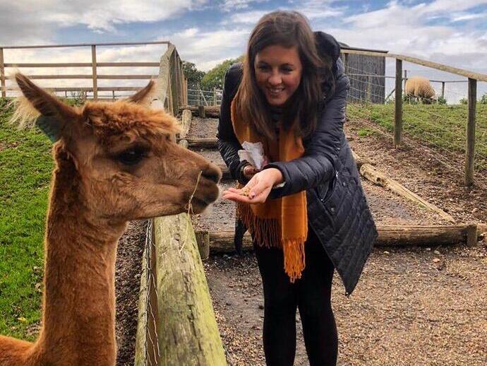 Woman feeding a llama from her hand