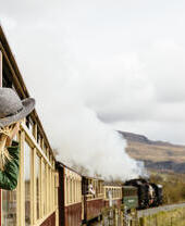 Woman looking out of window of traditional railway train