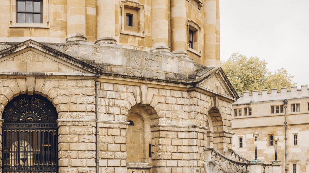 Two people sitting in an archway outside landmark building