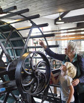 A grandparent and child looking at an industrial exhibit in Leeds Industrial Museum