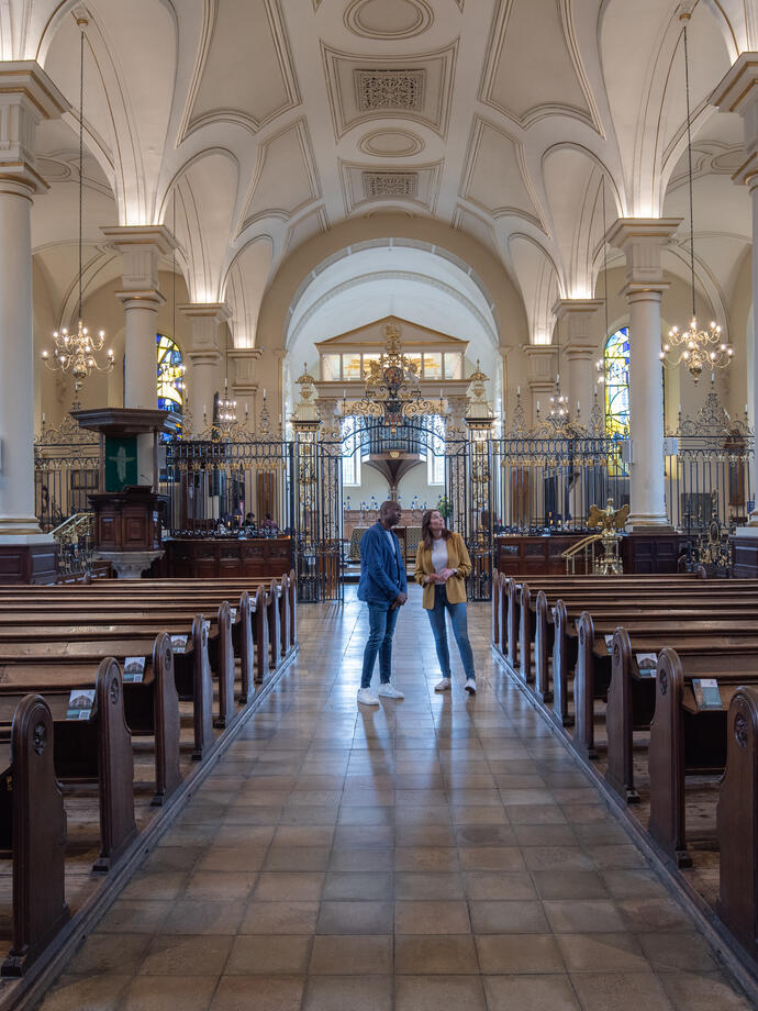 Zwei Personen stehen in einer Kathedrale