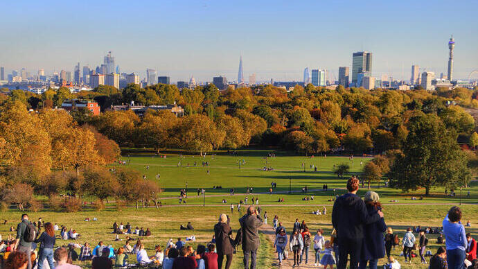 Vista soleada de otoño sobre un parque con el perfil urbano al fondo