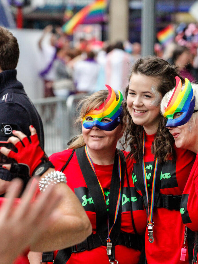 Women in rainbow masks celebrating Pride festival.