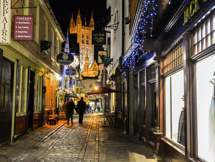 Man and woman walking along a street at night