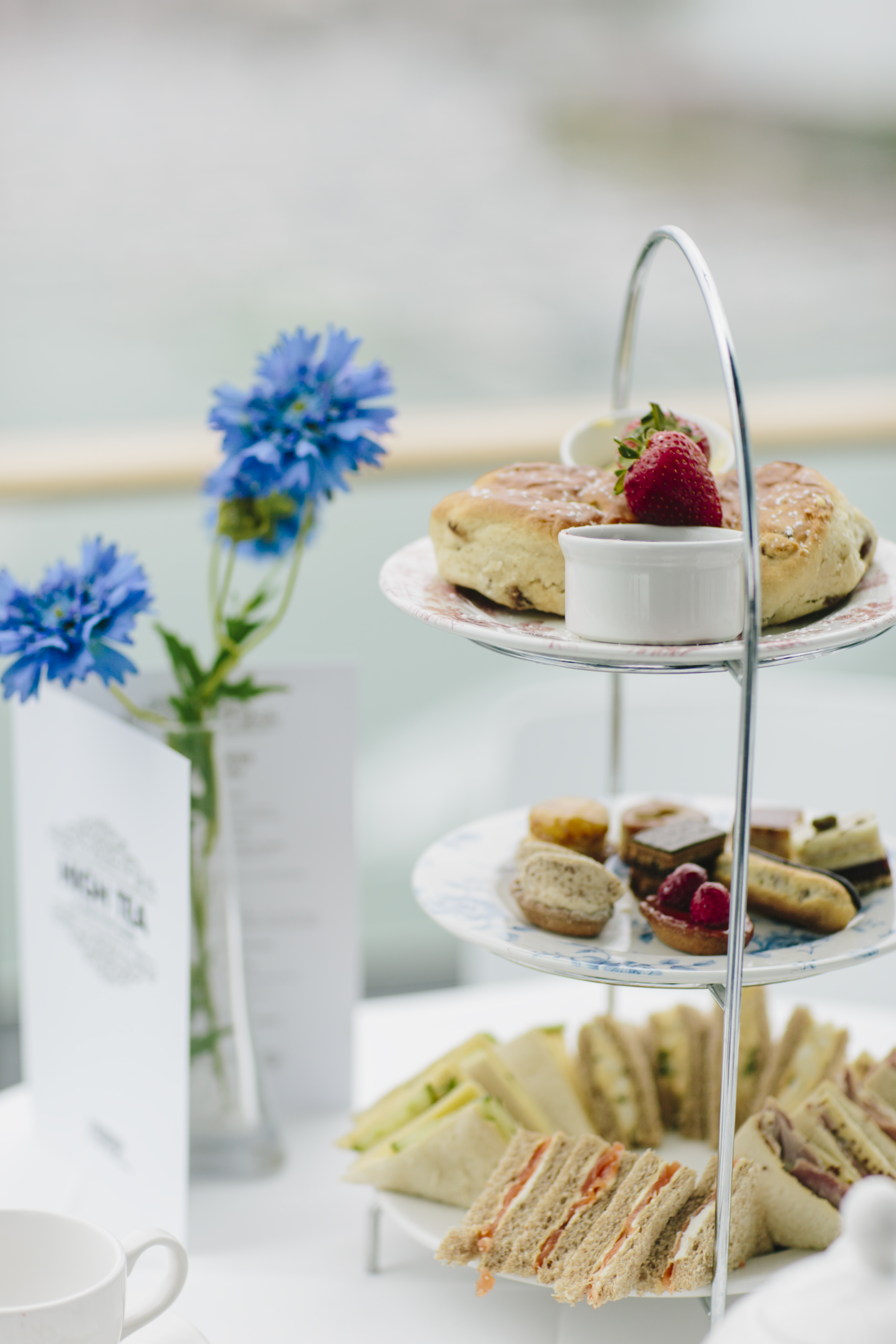 Meseta con sándwiches, bollos y pasteles sobre una mesa