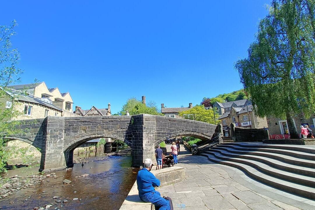 An historic packhorse bridge spanning a village stream in a rural country town.