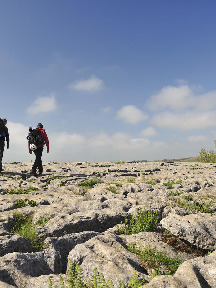 Menschen, die auf den Kalksteinfelsen oberhalb der Klippen spazieren gehen