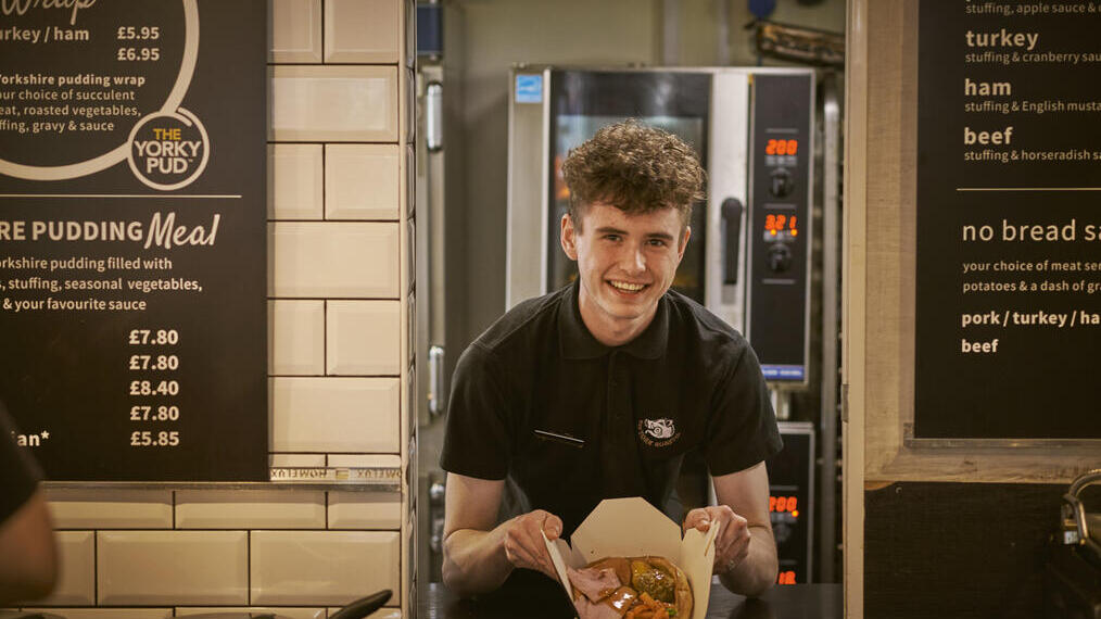 Man holding prepared food in a kitchen restaurant